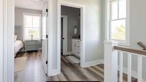 A spacious bedroom with a large bed, a nightstand, and a window.