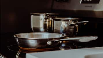 A kitchen with a stainless steel pan on an induction cooktop.