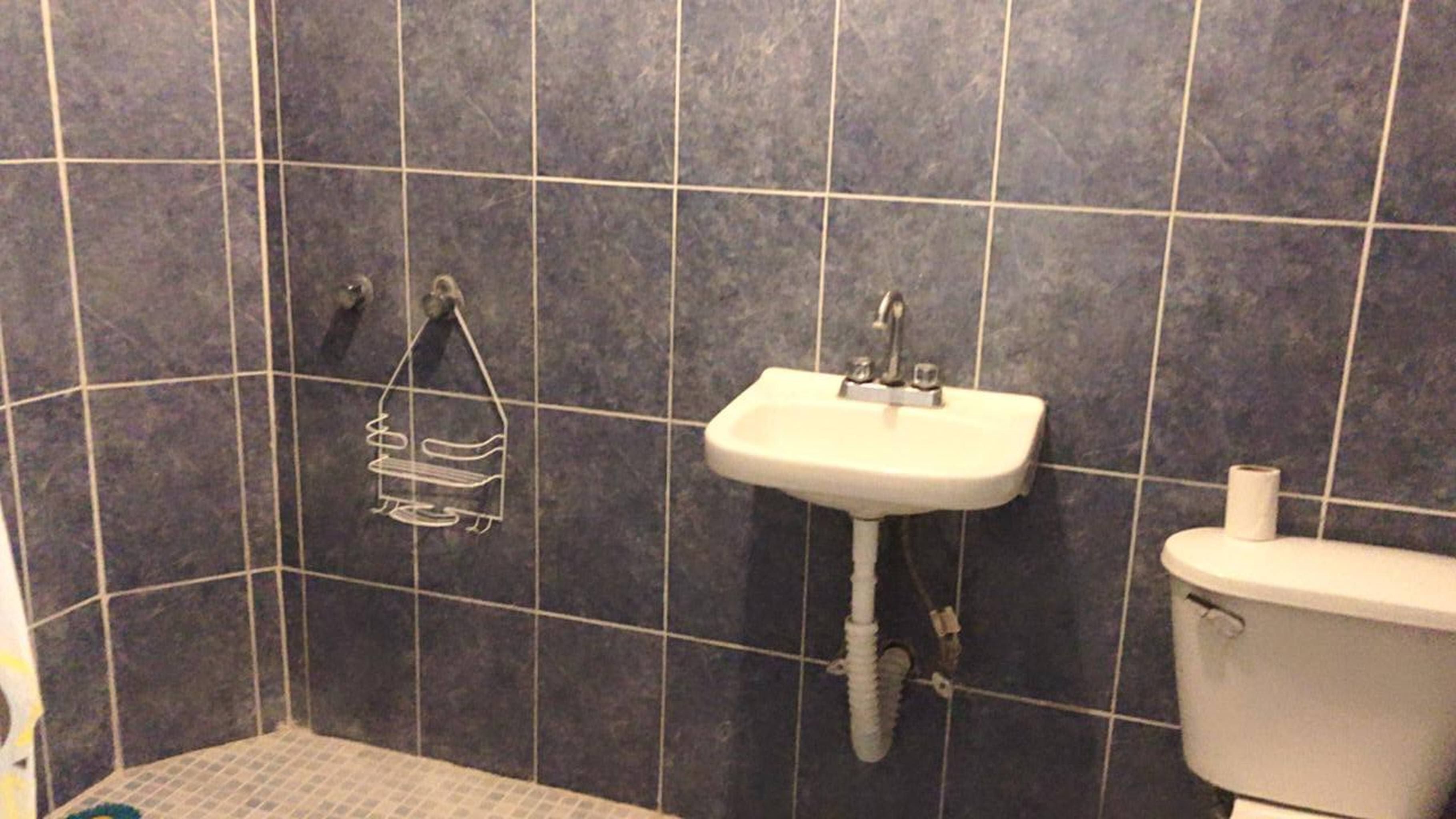 Een bad/douchecombinatie, handdoeken