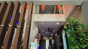 The entrance of Kha Juy Hotel 21 with a modern design, including a reception area, a staircase, and a seating area.