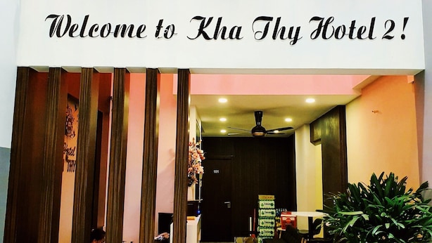 La entrada del hotel Kha Thy 2, con un mostrador de recepción, zona de estar y una planta grande en maceta.