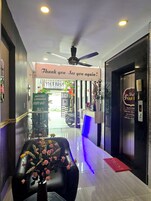 A hotel reception area with a ceiling fan, a sign reading "Thank you - See you again!", and a reception desk.