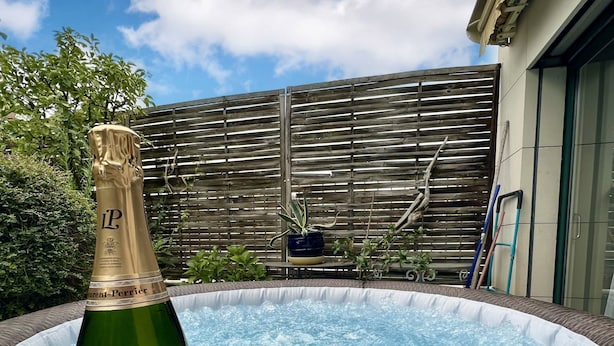 A hot tub with a bottle of champagne and two glasses. - Splendid House, Jacuzzi and Private Gardens Paris (Boulogne-Billancourt)
