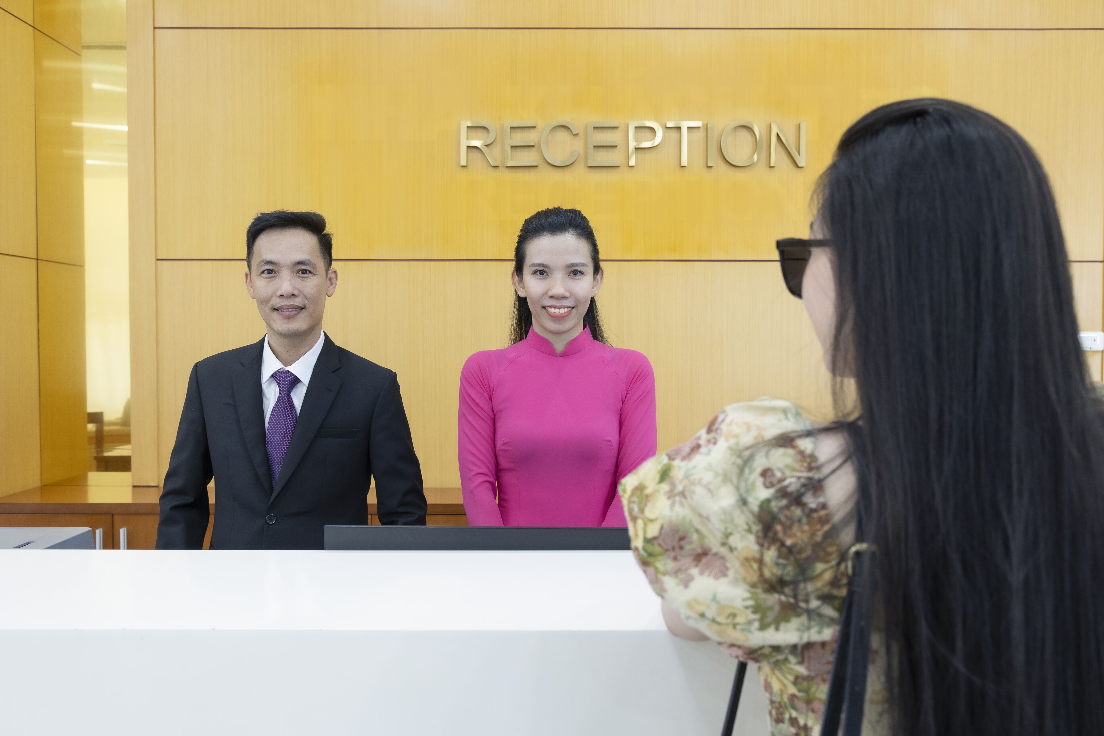 A reception area with a wooden wall and a sign that reads "RECEPTION".