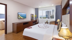 Une chambre d’hôtel avec un grand lit, un bureau, une télévision et une vue sur la ville.