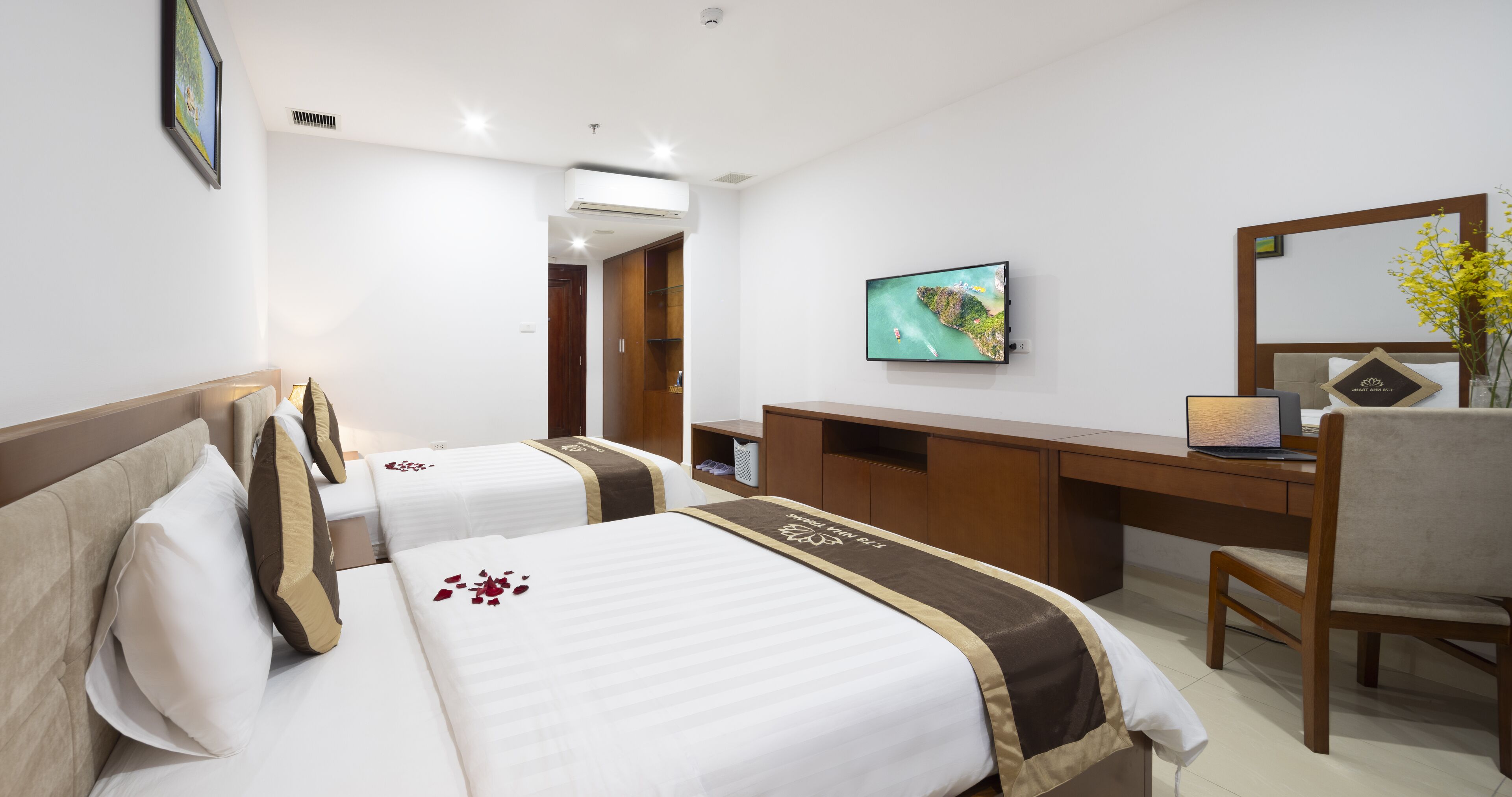 Een hotelkamer met twee bedden, een bureau, een stoel, een televisie en een spiegel.