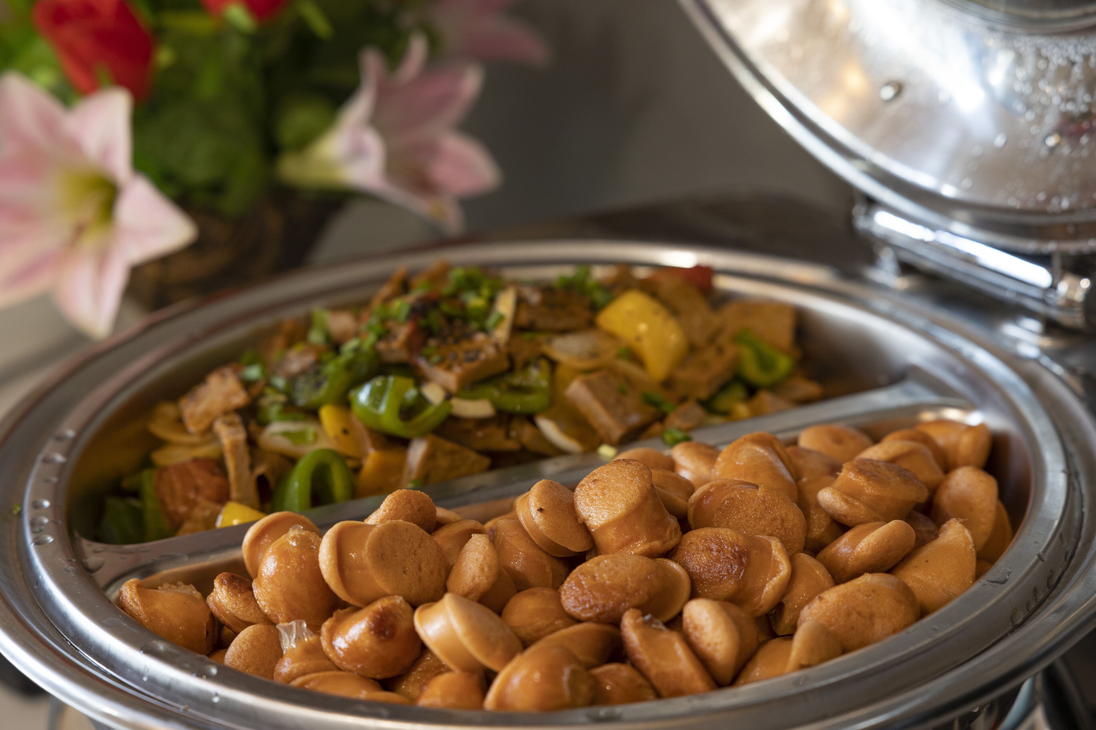 A buffet with various dishes including a section of fried items and a stir-fry dish.