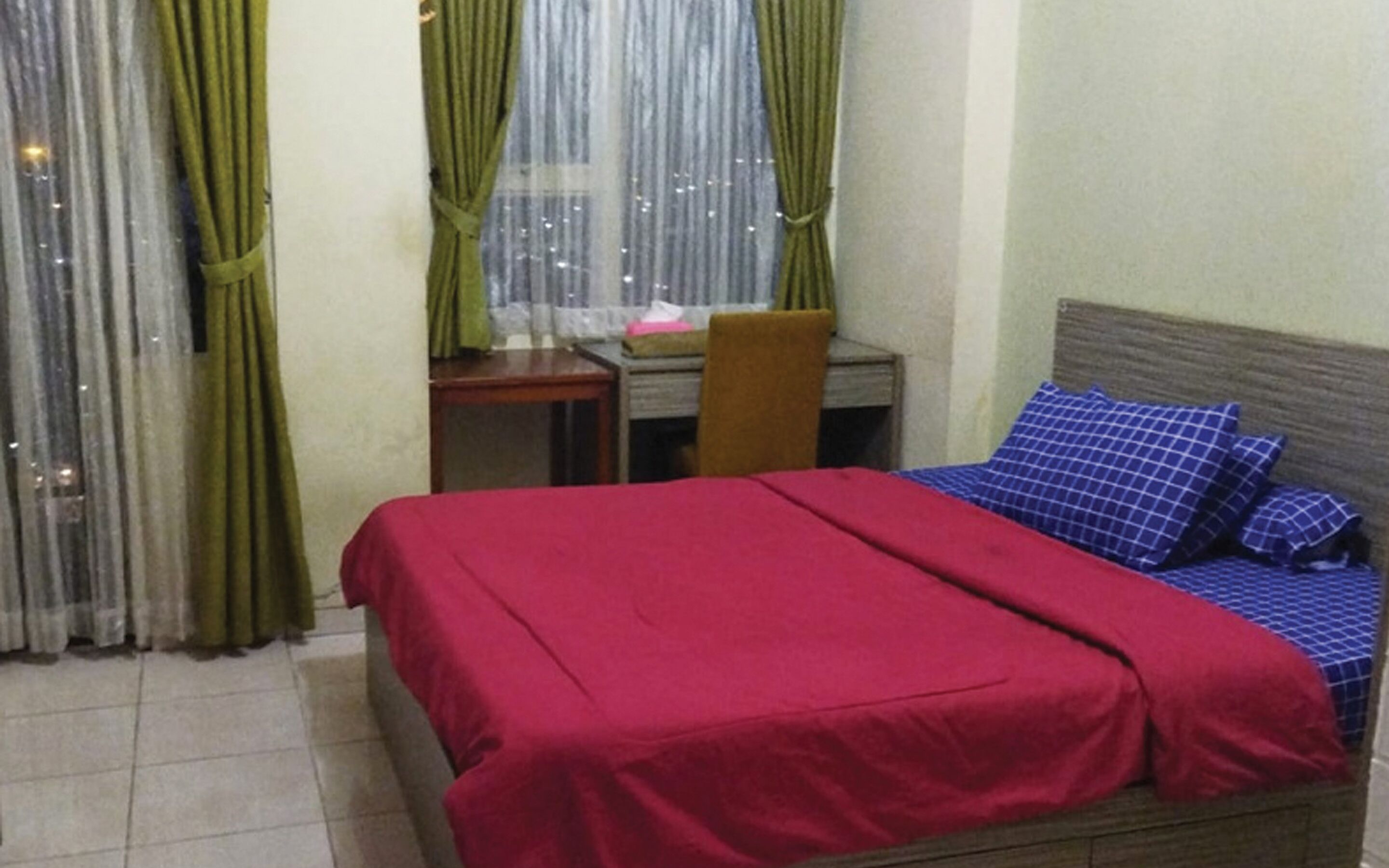 Una habitación con una cama, un escritorio y una silla.