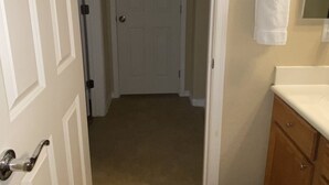 A hallway with a door leading to a bathroom. - Private access, private room, private bathroom (Goodyear)