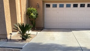 A concrete driveway leading to a garage with a tiled roof. - Private access, private room, private bathroom (Goodyear)