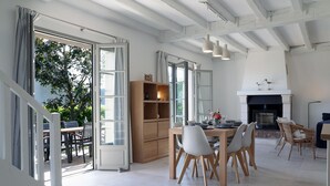A dining area with a wooden table and chairs, a bookshelf, and a fireplace.