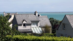 A coastal residential area with houses featuring sloped roofs and a view of the sea.