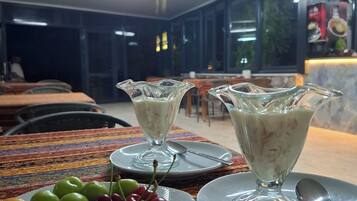 Un comedor con mesas, sillas y una barra de buffet.