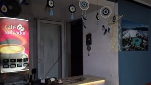 A café interior with a marble counter, dreamcatchers, and a wall-mounted sign for Café Salvador. - Paradise House  (Denizli)