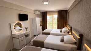 Habitación de hotel con dos camas, un escritorio con espejo, un armario y un televisor.