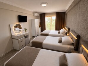 Habitación de hotel con dos camas, un escritorio con espejo, un armario y un televisor.
