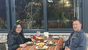 A dining area with a table set for two, featuring a patterned tablecloth and various dishes. - Paradise House  (Denizli)