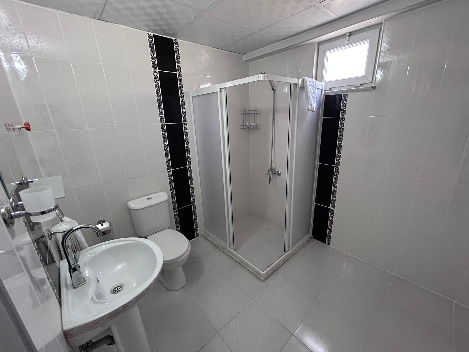 A bathroom with a toilet, sink, and shower.
