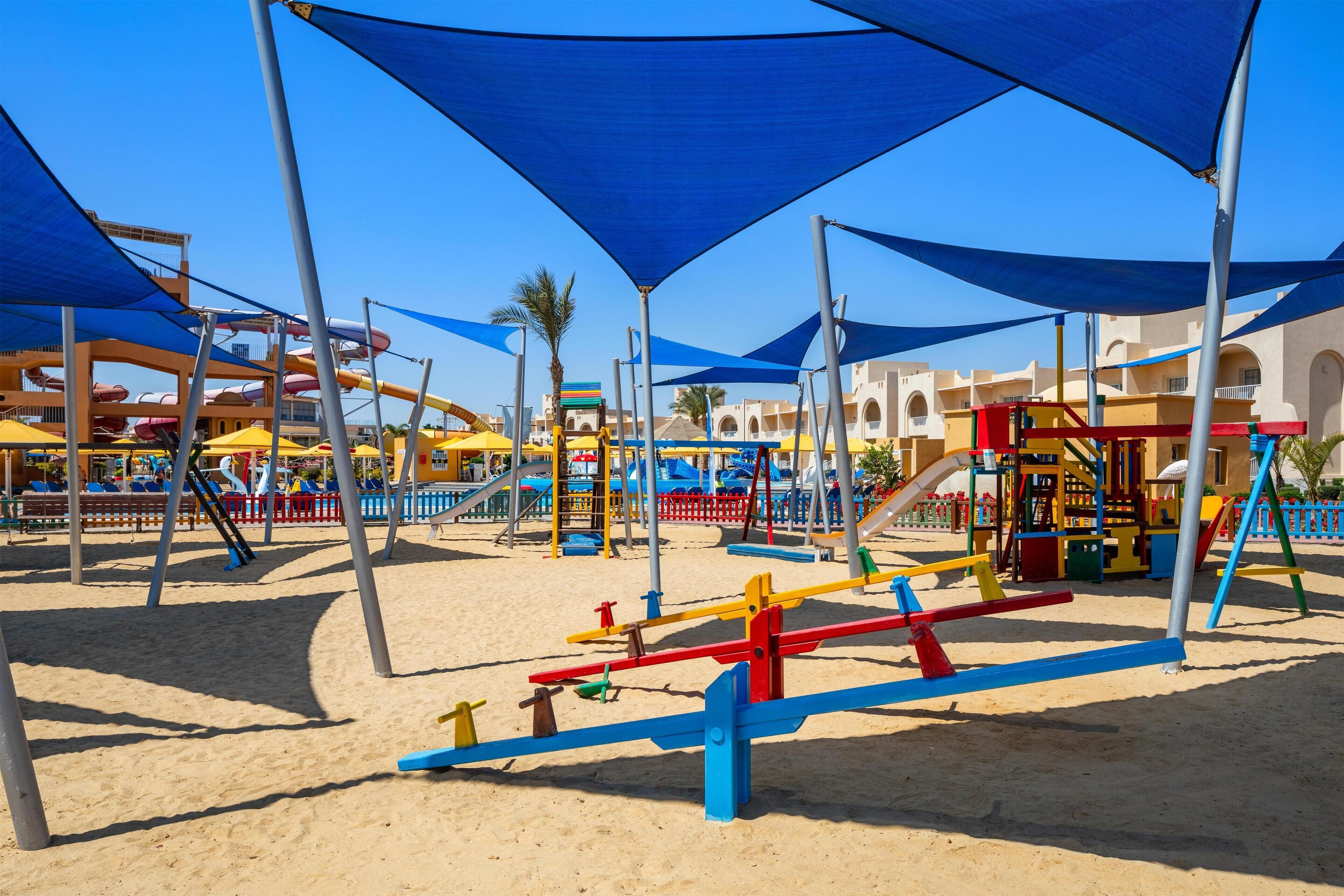 A playground with colorful equipment and blue shade structures.