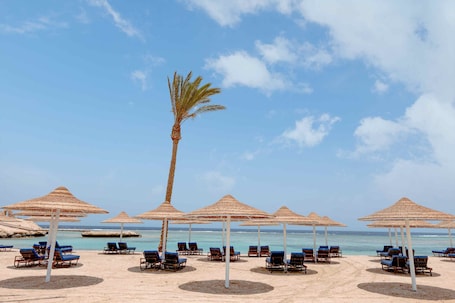 En la playa, sombrillas, toallas de playa, vóleibol de playa