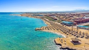 På stranden, parasoller, strandhanddukar och volleyboll