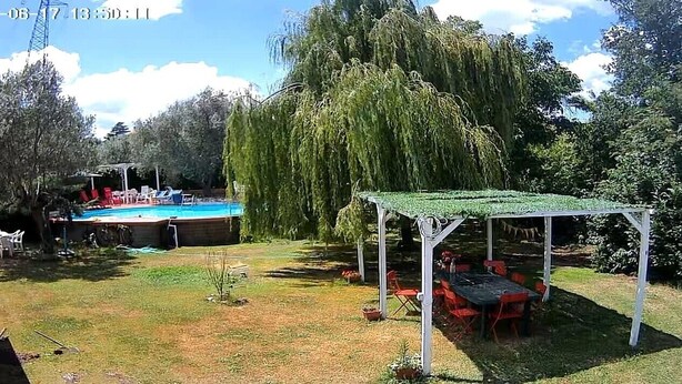 A backyard with a swimming pool, a covered seating area, and a weeping willow tree. - 150 sq. m. apartment in villa with private pool and Jacuzzi (Fabrica di Roma)