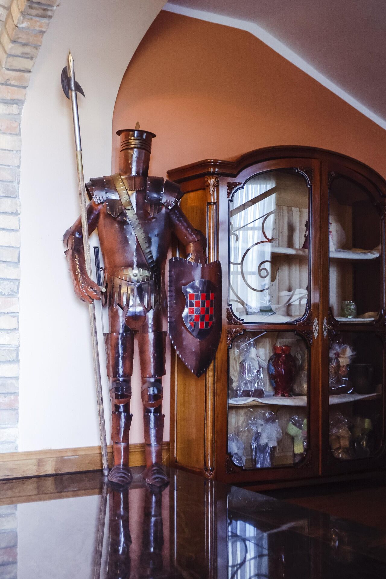 A wooden cabinet with glass doors displaying various items.