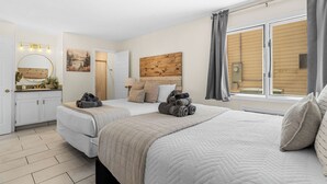 A bedroom with two beds, a vanity with a mirror, a painting, and a window with curtains. - Table Rock Lake Views | Pool Steps from Patio | 2 Private Suites (Kimberling City)