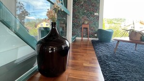 A modern interior with a large vase on a wooden table, a staircase with teal accents, and a view of the outdoors. - Exceptional mountain view, heated swimming pool, 10 minutes from Lake Annecy (sillingy)