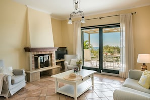Cozy living area with a fireplace, comfortable seating, and a view of the outdoors.