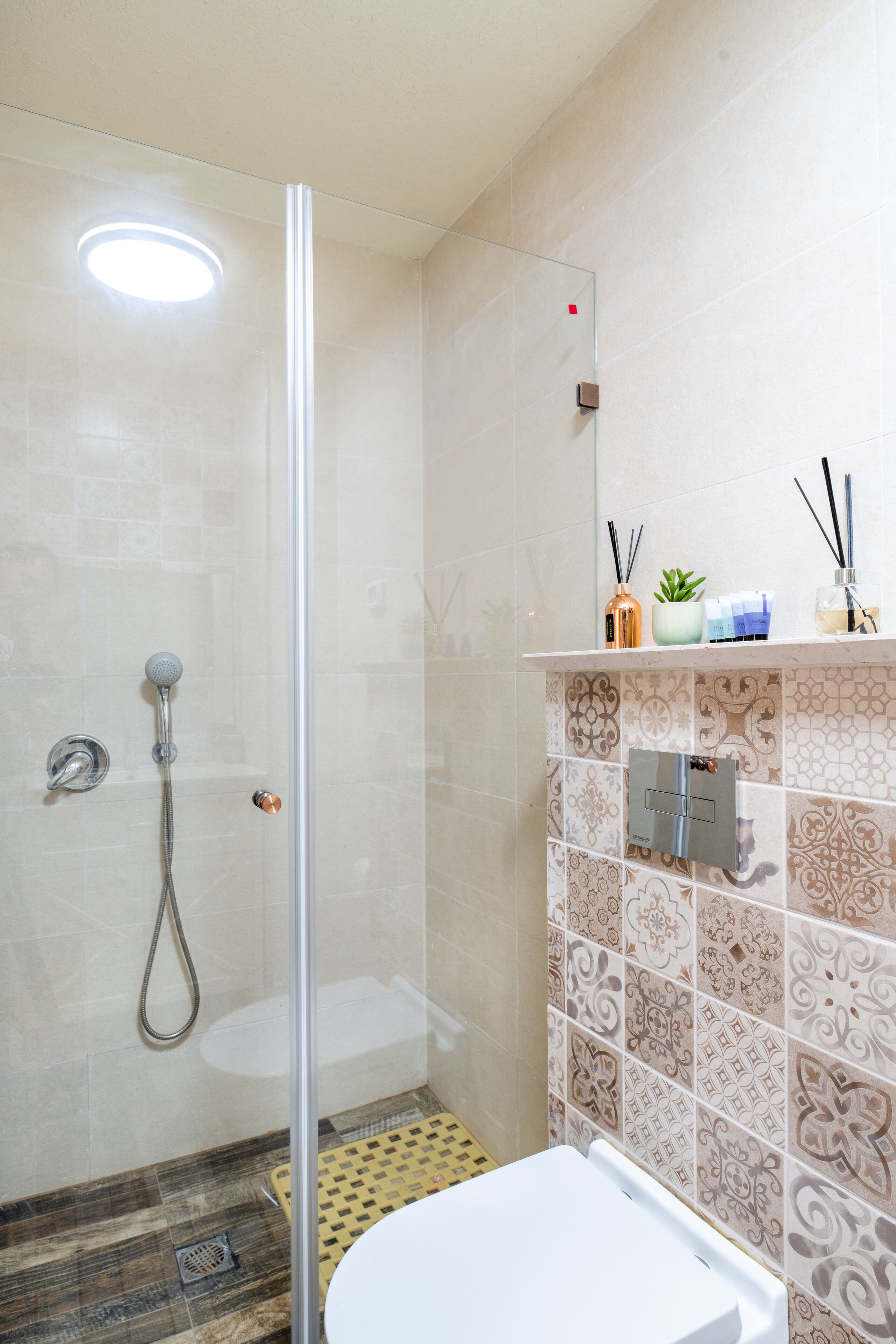 Un baño con cabina de ducha de vidrio, inodoro y lavabo.