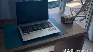 Un portatile su una scrivania vicino a una finestra con vista sull'oceano.