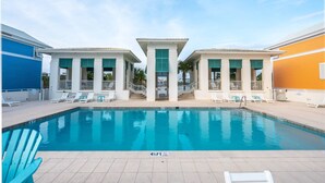 A swimming pool with a 4½ FT depth marker, surrounded by lounge chairs and a building with a white facade and green windows. - Walk to the Waves- Gorgeous Carillon Beach Bungalow (Panama City Beach)