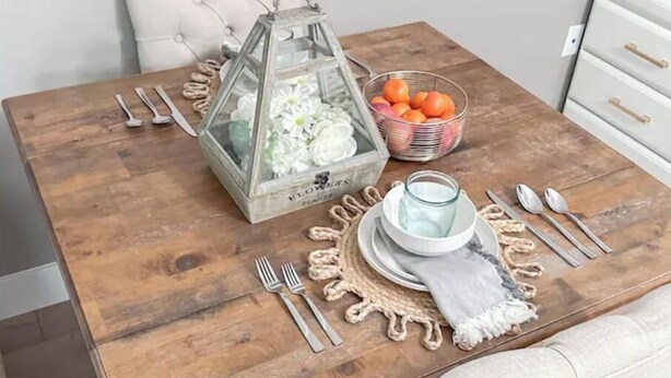 A dining table set with a glass lantern, a bowl of oranges, and a glass pitcher. - Private Entry Elegant Quiet Safe Cozy Studio Suite  (Pleasant Hill)