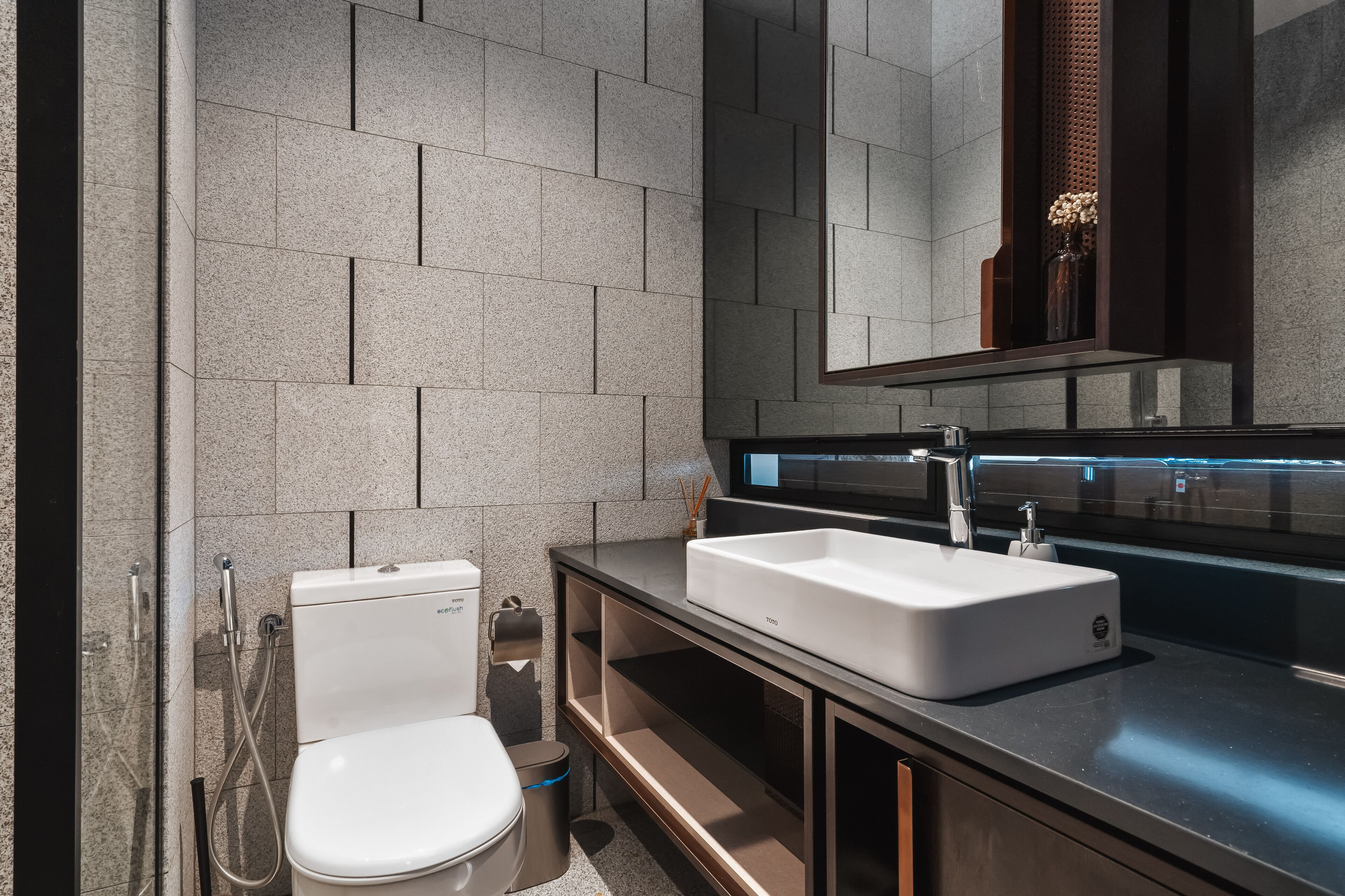 Un baño moderno con inodoro, lavabo y espejo.