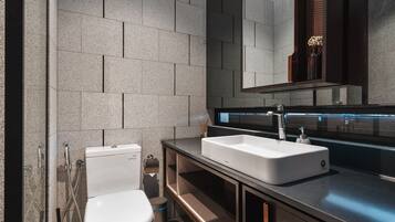 Un baño moderno con inodoro, lavabo y espejo.