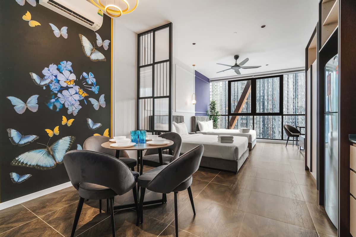 A modern living room with a dining area, large windows, and a ceiling fan.