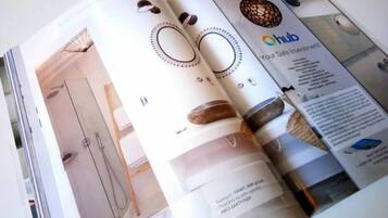 Une page de magazine présentant l’intérieur d’une salle de bain, avec une douche, des toilettes et un lavabo.