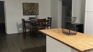 Una cucina moderna con un piano di lavoro in legno, un'area pranzo con sedie e un'isola cucina.