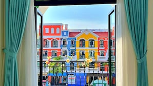 A balcony with a view of colorful buildings. - HANZ VeniceRiver Sunset Grand World (Phu Quoc)