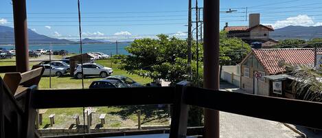 A covered outdoor area with a view of a parking lot and a body of water.