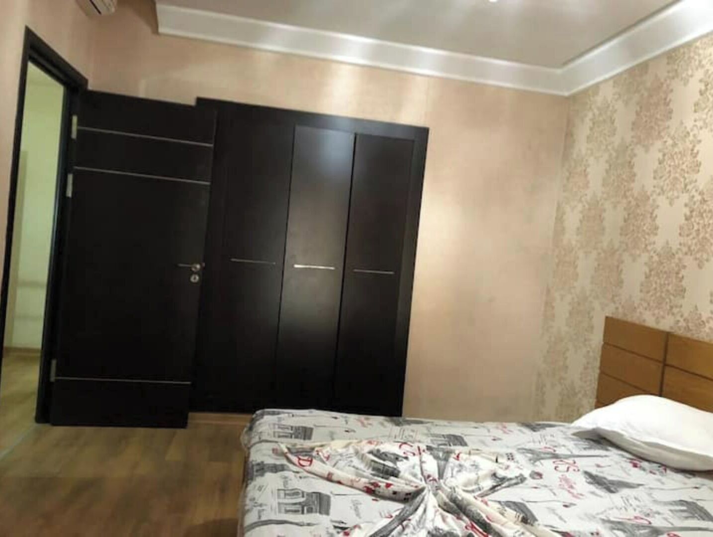 Une chambre à coucher avec un lit, une armoire et une porte.