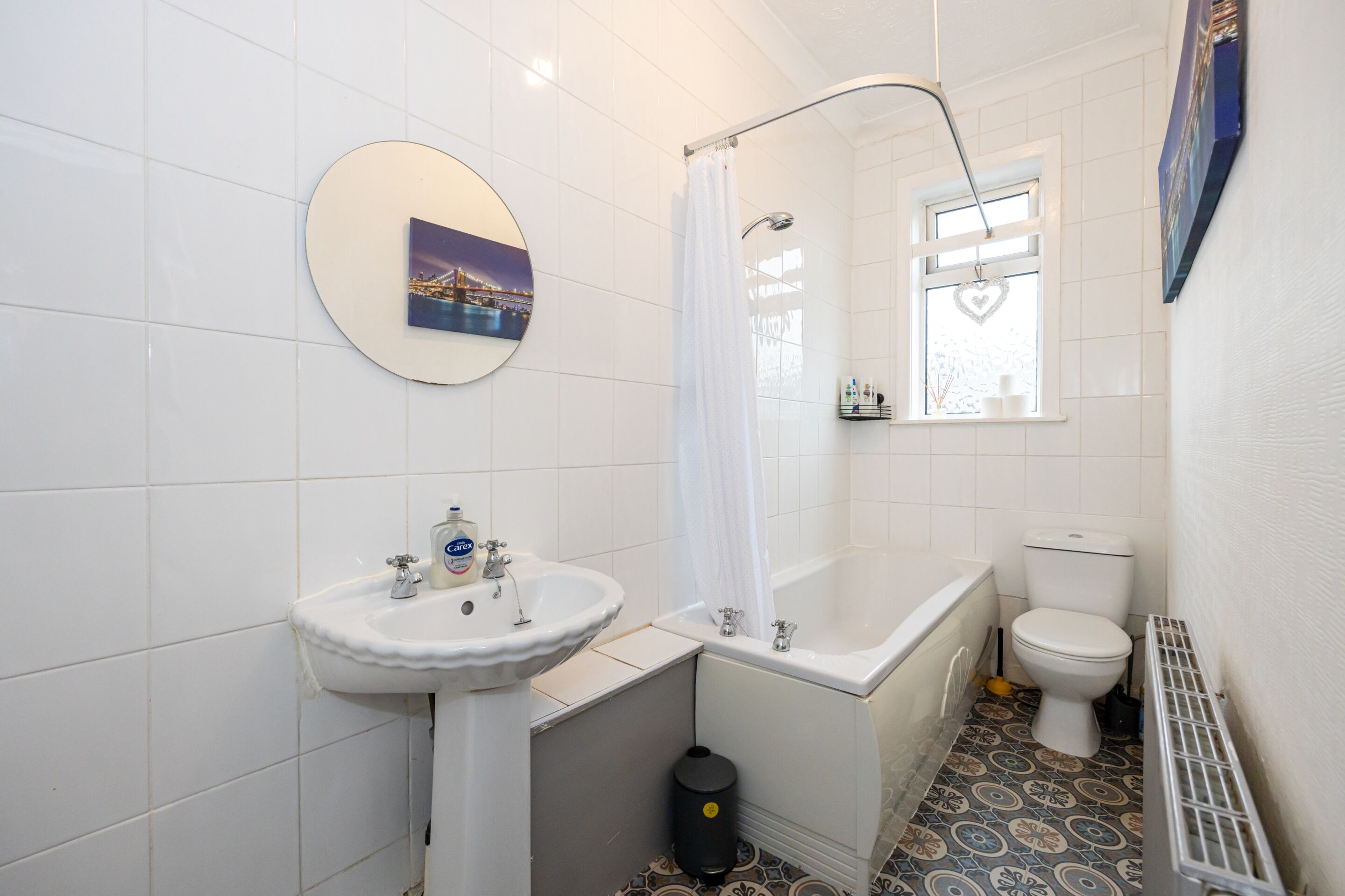 Un baño con un lavamanos blanco, una bañera, un inodoro y una cortina de ducha.