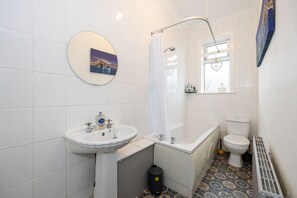 Een badkamer met een wit wastafel, een bad en een toilet.