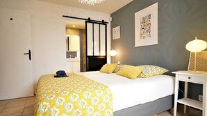 Une chambre d’hôtel avec un lit, une table de chevet, une lampe et une porte décorée d’une étoile.