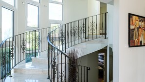 A spacious interior with a marble staircase, large windows, and a painting on the wall. - Cape Greco Villa Anastel 2 (Ayia Napa)