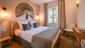 Ein Schlafzimmer mit Bett, Nachttisch, Stuhl und Wandventilator.