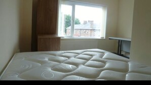 A bedroom with a bed, a window, and a radiator. - Luxurious Relaxing Room (Salford)