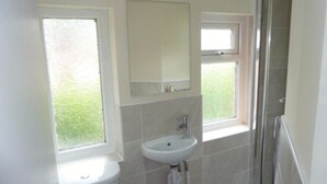 A bathroom with a sink, mirror, and two windows. - Luxurious Relaxing Room (Salford)