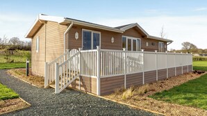 A single-story wooden house with a white porch and a small deck. - 2 bedroom accommodation in Willington, near Derby (Willington, near Derby)